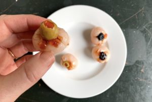 Stuff lychee with olives to make edible eyeballs